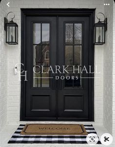 a black double door with two sidelights and a welcome mat