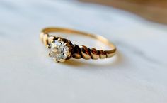 a close up of a gold ring with a diamond