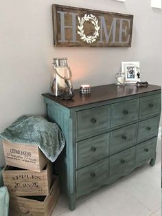 an old dresser is turned into a sideboard in the living room with boxes stacked on top