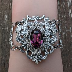 This unique Amethyst bracelet is made with sterling silver plated brass vintage stampings that form a gothic/fantasy look. The center 16x11mm stone is a vintage Swarovski crystal (no longer in production). The bracelet measures 2" tall and 7.5" long, which will fit most women's wrists. I offer two options for the closure:1. A steel slider chain that is easy to adjust and secure.2. A sterling silver plated brass cable chain with a lobster claw closure. If you need longer chain, then please let me Vintage Gothic, Long Chain, Amethyst Bracelet, Gothic Jewelry, Amethyst Crystal, Cable Chain, Swarovski Crystals, Vintage Jewelry, Amethyst