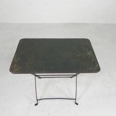 a small metal table sitting on top of a white floor