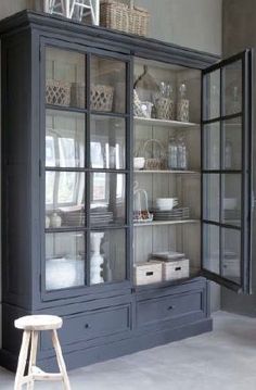 a large china cabinet with glass doors and shelves