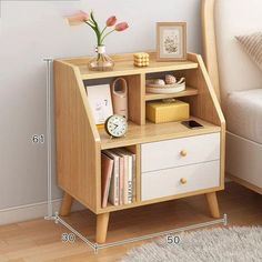 a small wooden shelf with drawers next to a bed and a clock on top of it