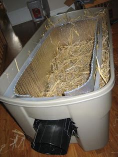 a bucket with hay in it sitting on the floor