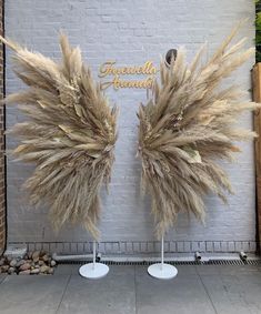 two tall feathers are on display in front of a brick wall with the words farewell friends