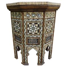 an intricately decorated wooden table with geometric designs on the top and bottom, against a white background