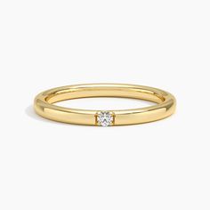 a yellow gold ring with a single diamond