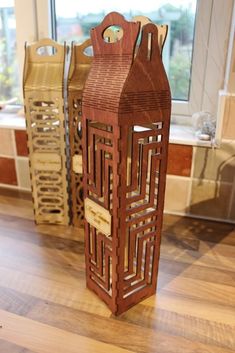 a wooden sculpture sitting on top of a hard wood floor next to a large window