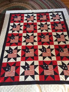 an american flag quilt is displayed on a bed