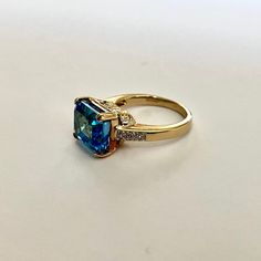 Gorgeous large emerald cut bright blue topaz vintage ring set with small white spinel on the shoulders, and in solid hallmarked 9ct yellow gold, which has moulded flower motifs on the setting under the central stone. CONDITION: Excellent  TOPAZ SIZE: 11mm x 9mm CURRENT FINGER SIZE: UK finger size  N 1/2 ( can be altered to sizes on drop down menu ). WEIGHT: 5.4g This amazing ring has been professionally checked, cleaned and polished. Comes in a new box. Emerald Cut Topaz Ring In Yellow Gold, Emerald Cut Yellow Gold Topaz Ring, Asscher Cut Topaz Ring Fine Jewelry For Formal Occasions, Asscher Cut Topaz Ring For Formal Occasions, Formal Princess Cut Topaz Ring With Center Stone, Classic Blue Topaz Emerald Cut Ring, Classic Emerald-cut Blue Topaz Ring, Classic Emerald Cut Blue Topaz Ring, Fine Jewelry Asscher Cut Topaz Ring For Anniversary