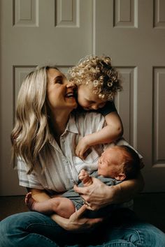 a woman holding a baby and smiling at the camera while she holds it up to her face