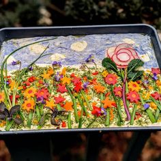 there is a cake decorated with flowers and leaves on the table top in the shape of a flower garden