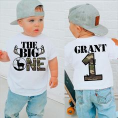 two toddlers wearing matching shirts with the number one and the word, the big one