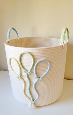 a white basket with scissors on it sitting on a table next to a lamp shade