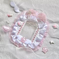 a pink and white collar with hearts, stars, and other accessories on a bed