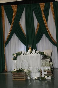 the table is set up for a wedding reception with white flowers and greenery on it