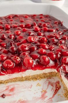 a large cake with cherries on top in a white dish, ready to be eaten