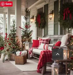 a porch decorated for christmas with red and white plaid pillows, wreaths and trees