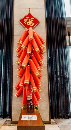 a bunch of red and gold decorations on display in a room with black drapes