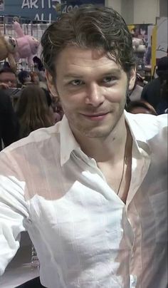 a man in white shirt sitting at a table