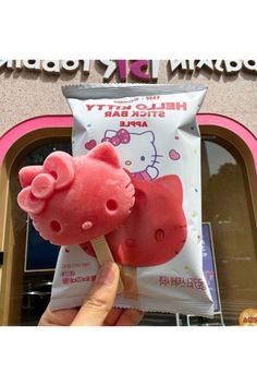 a hello kitty apple is being held in front of a store