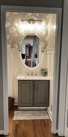 an open door leading to a bathroom with a sink and mirror on the wall above it