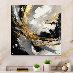 an abstract painting in gold and black on a white wall above a fireplace mantel