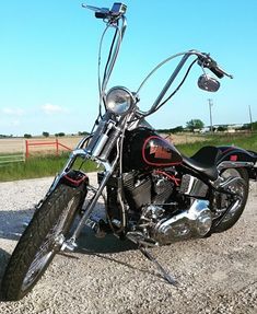 a black motorcycle parked on top of a gravel road