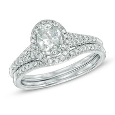 an oval cut diamond engagement ring set with two matching bands on each band and the center stone