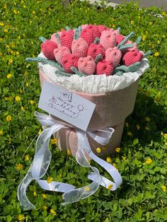 a basket filled with strawberries sitting on top of a lush green field