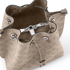 LOUIS VUITTON® - Muria - Galet Luxury Beige Bucket Bag, Designer Bags With Silver-tone Hardware And Monogram Canvas, Designer Bags In Monogram Canvas With Silver-tone Hardware, Travel Bag With Monogram Canvas And Silver-tone Hardware, Luxury Bucket Bag With Silver-tone Hardware, Louis Vuitton Official, Perforated Leather, Leather Cord, Calf Leather