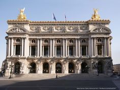 an ornate building with statues on the front and side of it's facade, in a city square