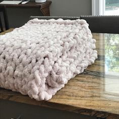 a white blanket sitting on top of a wooden table