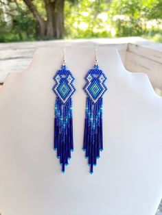 These Beautiful Native American Beaded Earrings are custom made by Elaine out of Blue, White, Turquoise and Silver with blue bugle beads on them.  They are 5 inch long and 1 inch wide with silver ear wires on them, can be changed to post or clips. If you like them and want in another color just let me know I do special orders.  Thanks for looking. Artisan Blue Earrings For Festival, Artisan Blue Earrings With Dangling Beads, Southwestern Style Blue Earrings For Festivals, Southwestern Style Blue Festival Earrings, Southwestern Blue Beaded Earrings With Round Beads, Southwestern Blue Earrings With Ear Wire, Southwestern Blue Drop Earrings, Southwestern Style Blue Drop Earrings, Southwestern Style Blue Beaded Earrings