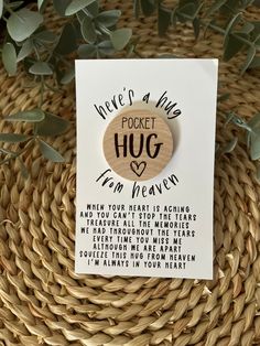 a wooden brooch with the words pocket hug on it and a card attached to it