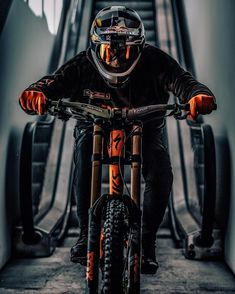 a man riding on the back of a dirt bike down a flight of escalators