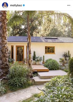 a white house surrounded by trees and plants