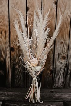 a bouquet of dried flowers sitting on top of a wooden table