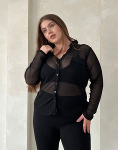 With its sleek and flattering silhouette, the Plus Size Sheer Ribbed Button Up Shirt offers a trending way update to your workwear wardrobe. Wear this plus size sheer top with a cute bralette underneath to give the full effect and a pair of trousers for a street style outfit that's very on trend right now. This top features buttons up the front, long sleeves, a v-shaped neckline, a folded-down collar, and a single chest pocket. The material is a sheer, stretchy knit material. This shirt is made Sheer Shirt Outfits, Outfits For Plus Size Women, Mesh Button Up, Workwear Wardrobe, Chubby Fashion, Sheer Shirt, Sheer Top, Street Style Outfit, Fall Trends