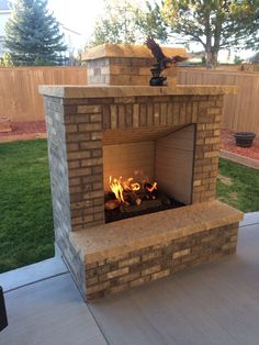 an outdoor fireplace in the middle of a patio