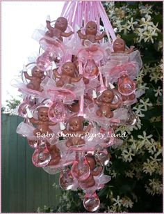 a pink chandelier with teddy bears hanging from it