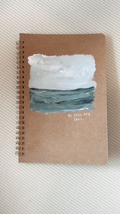 a spiral notebook with watercolors on it