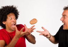 two men with their mouths open and one has a cookie in his hand