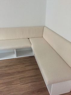 a white couch sitting on top of a hard wood floor