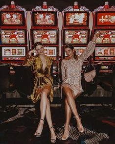 two women sitting next to each other in front of slot machines