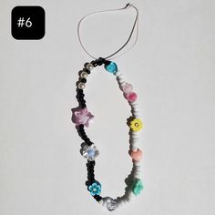 a necklace with beads and charms hanging from it's side on a white background