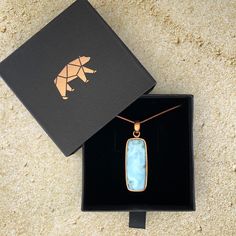 The most beautiful gemstone found only in the Dominican Republic, Larimar is a stone of coolness and calm, much like the native waters it resembles. Larimar is a powerful healer! It can help with panic attacks, anger, fear and other stress-related issues. Secure this unique and beautiful one-of-a-kind Larimar pendant around your neck and breathe in the calm of the Caribbean ocean! Includes a 24" copper-plated snake chain (electroplated brass in antique copper color) Lead-free; nickel-safe Bezel-set in copper Pendant is approximately 2.16”H (55mm) x .66”W (16.9mm) Comes in our exclusive luxury gift box Source: Dominican Republic Any visible imperfections and/or cracks are due to natural formation Product color may slightly vary due to photographic lighting sources! Disclaimer: Crystals shou Caribbean Ocean, Larimar Pendant, The Dominican Republic, Copper Pendant, Luxury Gift Box, Copper Pendants, Copper Plated, Copper Color, Beautiful One