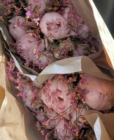 a bunch of flowers that are in some kind of wrapper on a table with paper