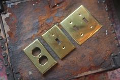 two metal plates sitting on top of a piece of leather covered in rivets