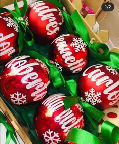 christmas ornaments are in a box with green ribbon